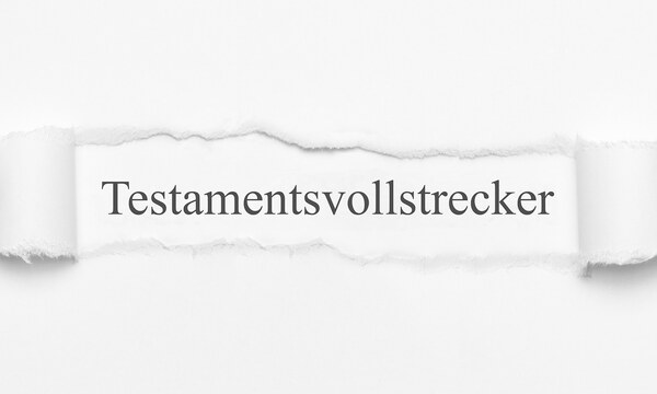 Ein Bogen Papier, in dessen Mitte ein Loch gerissen wurde. In diesem Loch befindet sich Text in Serifenschrift: "Testamentsvollstrecker".