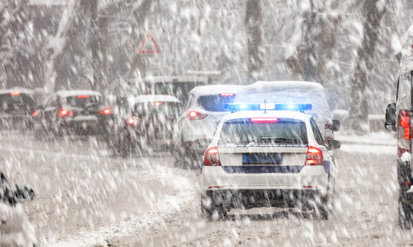 Autoverkehr staut sich auf einer verschneiten Straße.