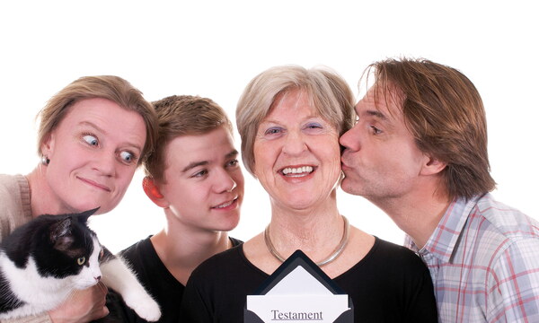 Eine ältere Dame hält einen geöffneten Umschlag mit einem Testament vor sich. Um sie herum drängt sich die Verwandschaft und schielt auf das Testament.